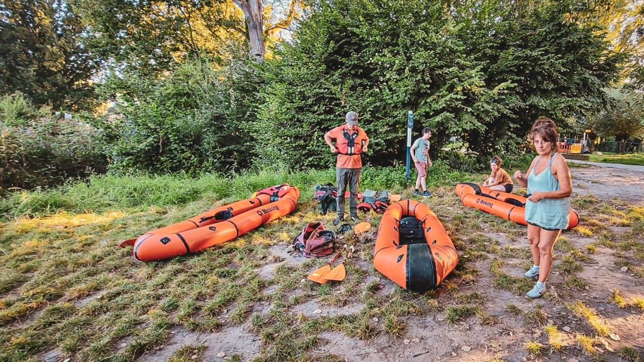 Het team is klaar voor een packraftavontuur aan de oever van een rivier, midden in de natuur.