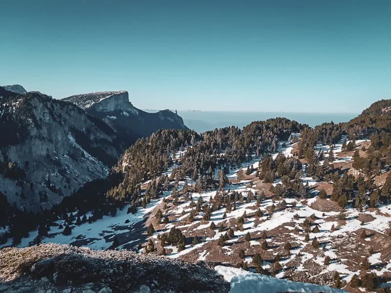 Een uitgestrekt panorama van de bergen van de Vercors, tussen bos en sneeuw, nodigt uit tot een avontuur in de wildernis.