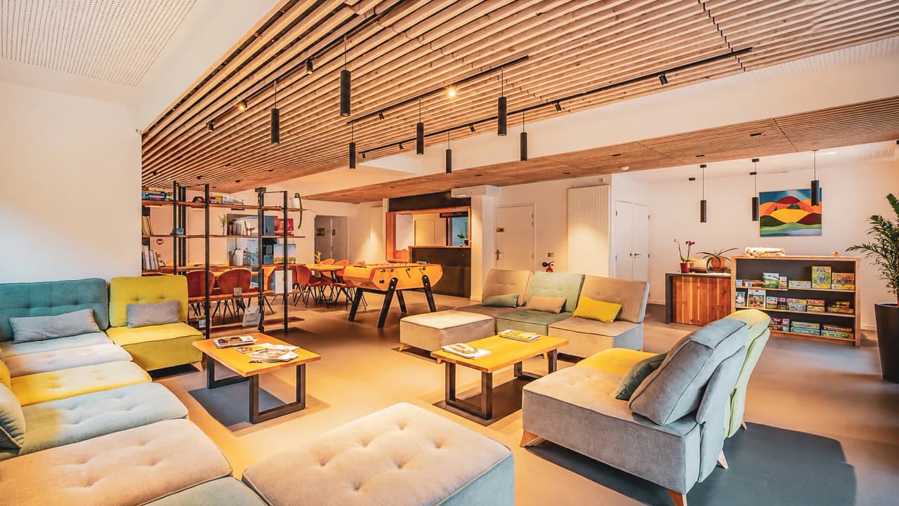 A modern, welcoming lounge area with colourful sofas, games and a friendly atmosphere.