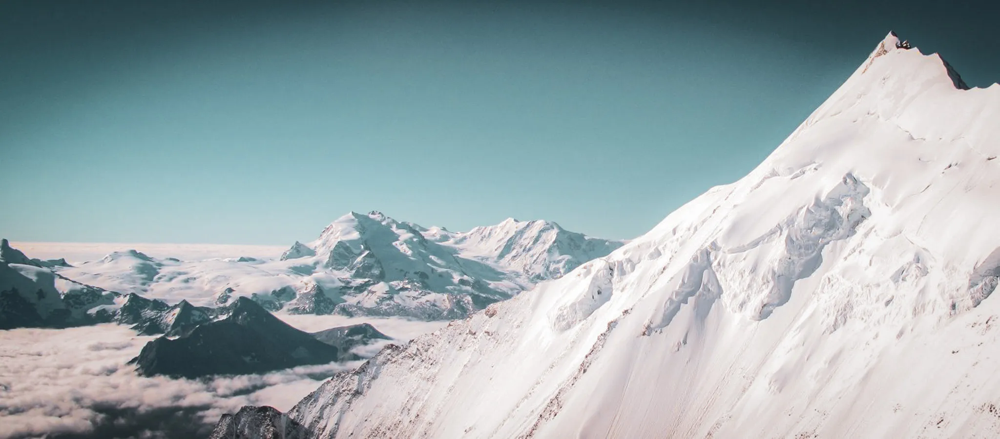 Majestic views of the Swiss Alps, with snow-capped peaks and clear blue skies inviting adventure.