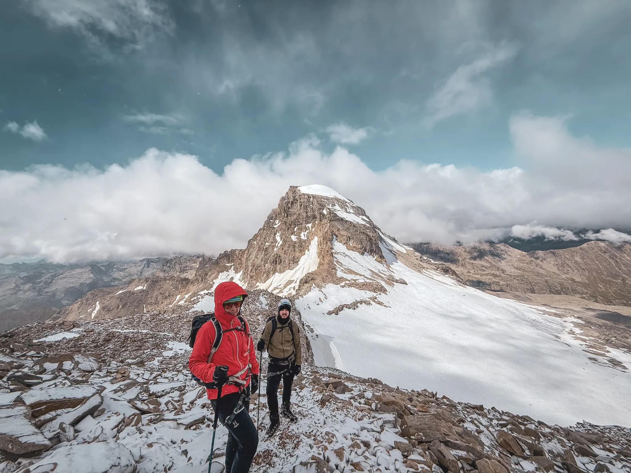 Two climbers on their way to the summit of Gran Paradiso, with a spectacular snow-covered landscape.