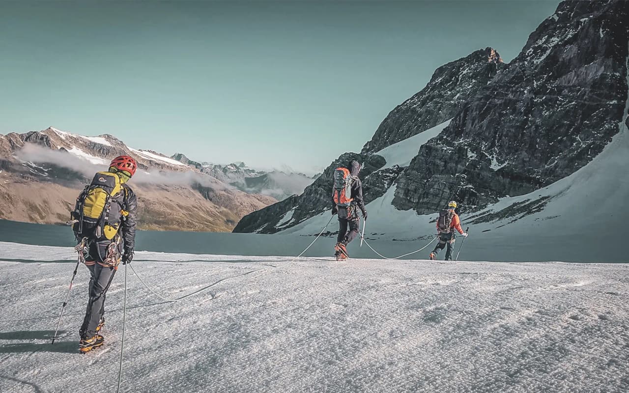 Alpinistes en randonnée sur un glacier, avec paysages majestueux de Chamonix en arrière-plan.
