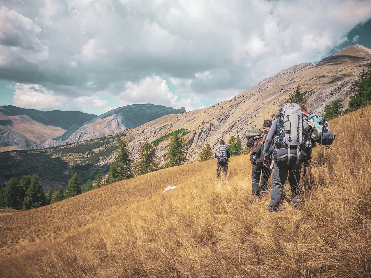 Groupe de randonneurs au cœur des Alpes, dans un paysage sauvage et majestueux.