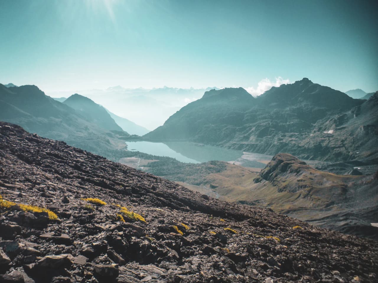 Panoramic views of the Alps, with a sparkling lake set amid majestic scenery.