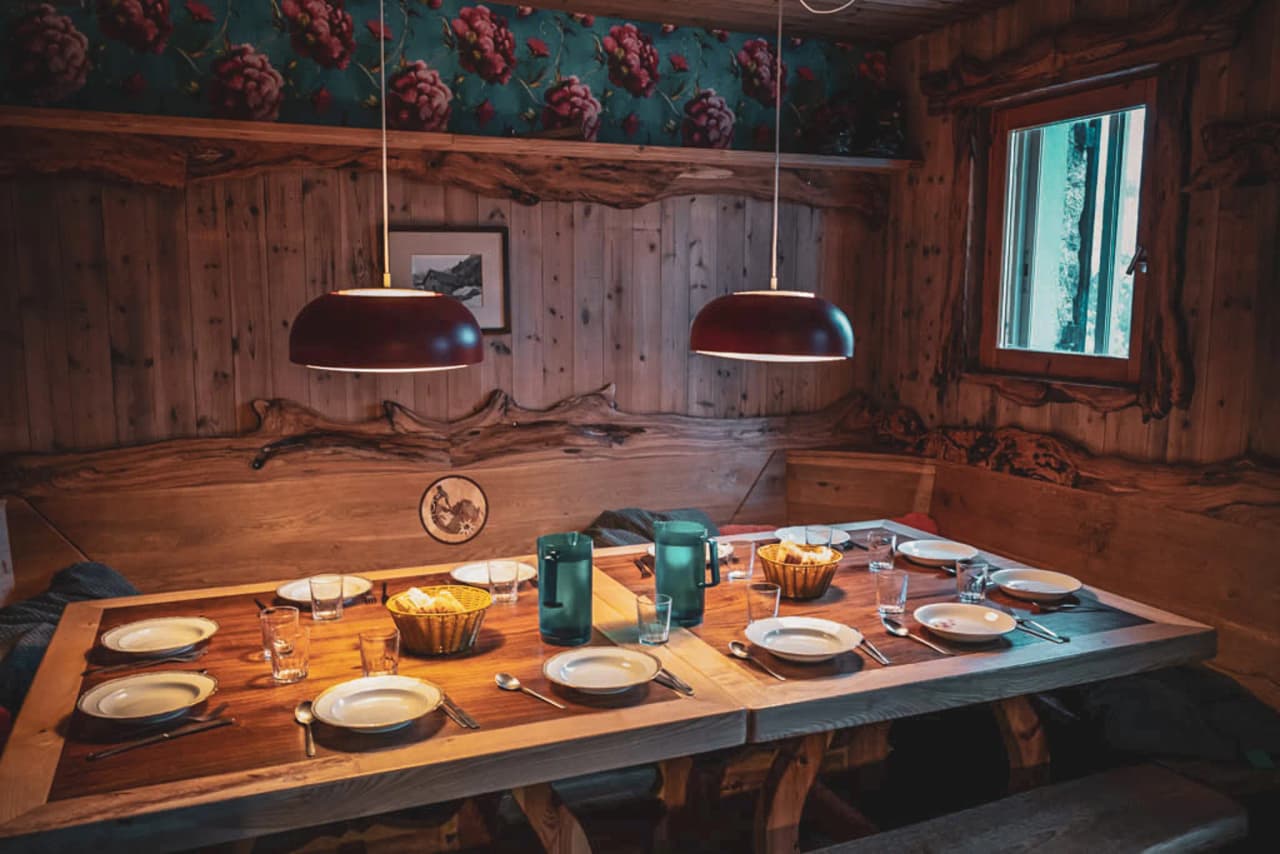 A warmly laid table in a wooden Mountain hut, ready for a feast after the adventure.