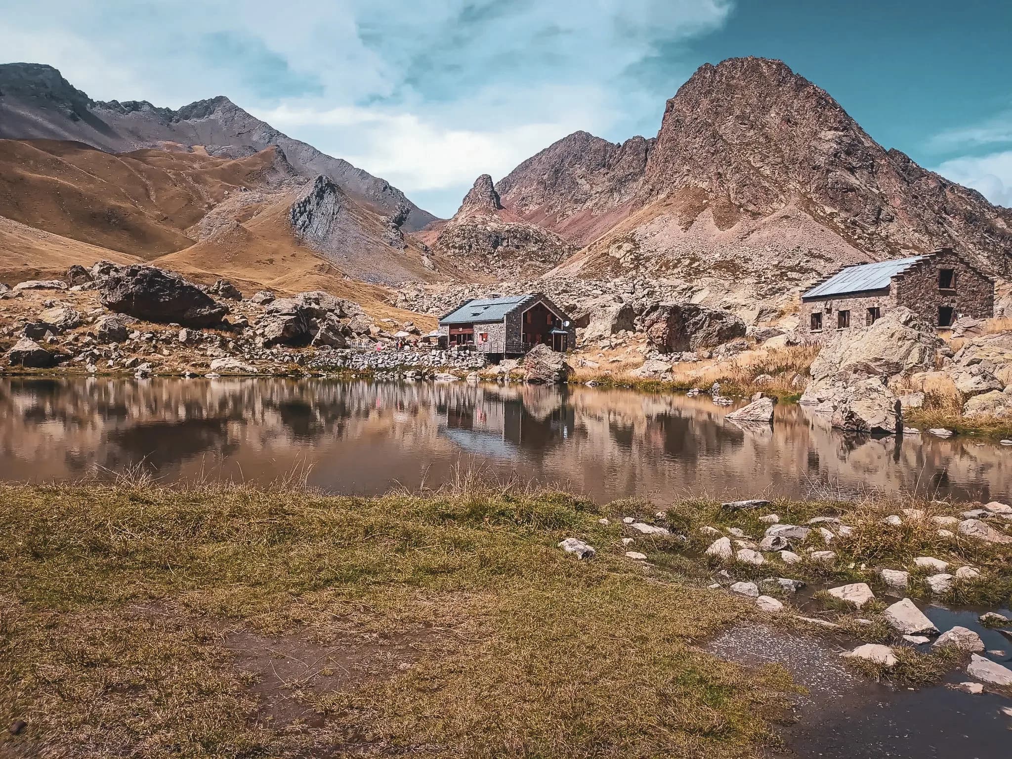 Een vredig bivak bij een meer, omringd door majestueuze bergen en wildernis.
