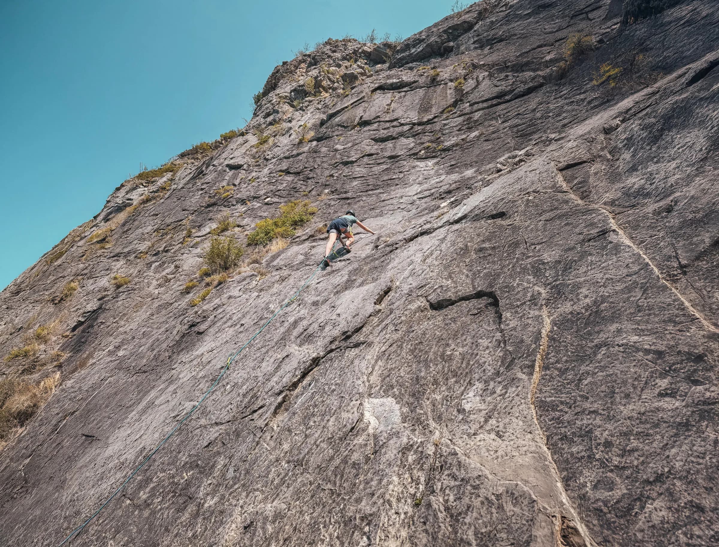 Climbing majestic rocks, under an azure sky, between adventure and alpine nature.