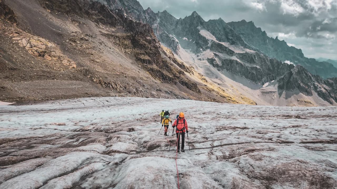 Alpinistes sur un glacier des Écrins, entourés de majestueuses montagnes. Aventure assurée !