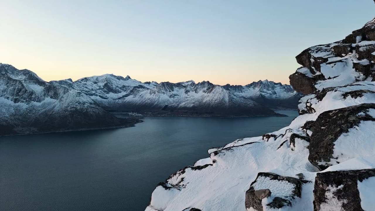 Spectacular view of the Senja fjords, Norway, with majestic mountains and glistening snow.