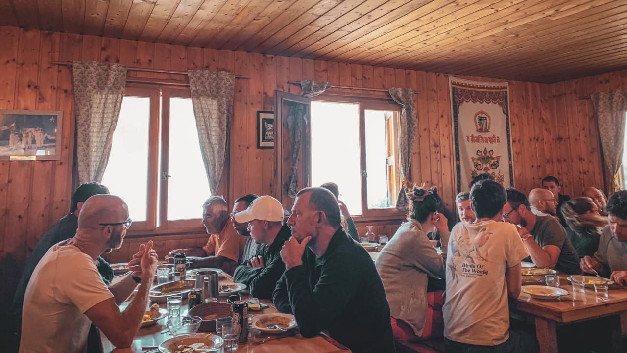Scène conviviale d'un repas en montagne, ambiance chaleureuse et conviviale dans un refuge.