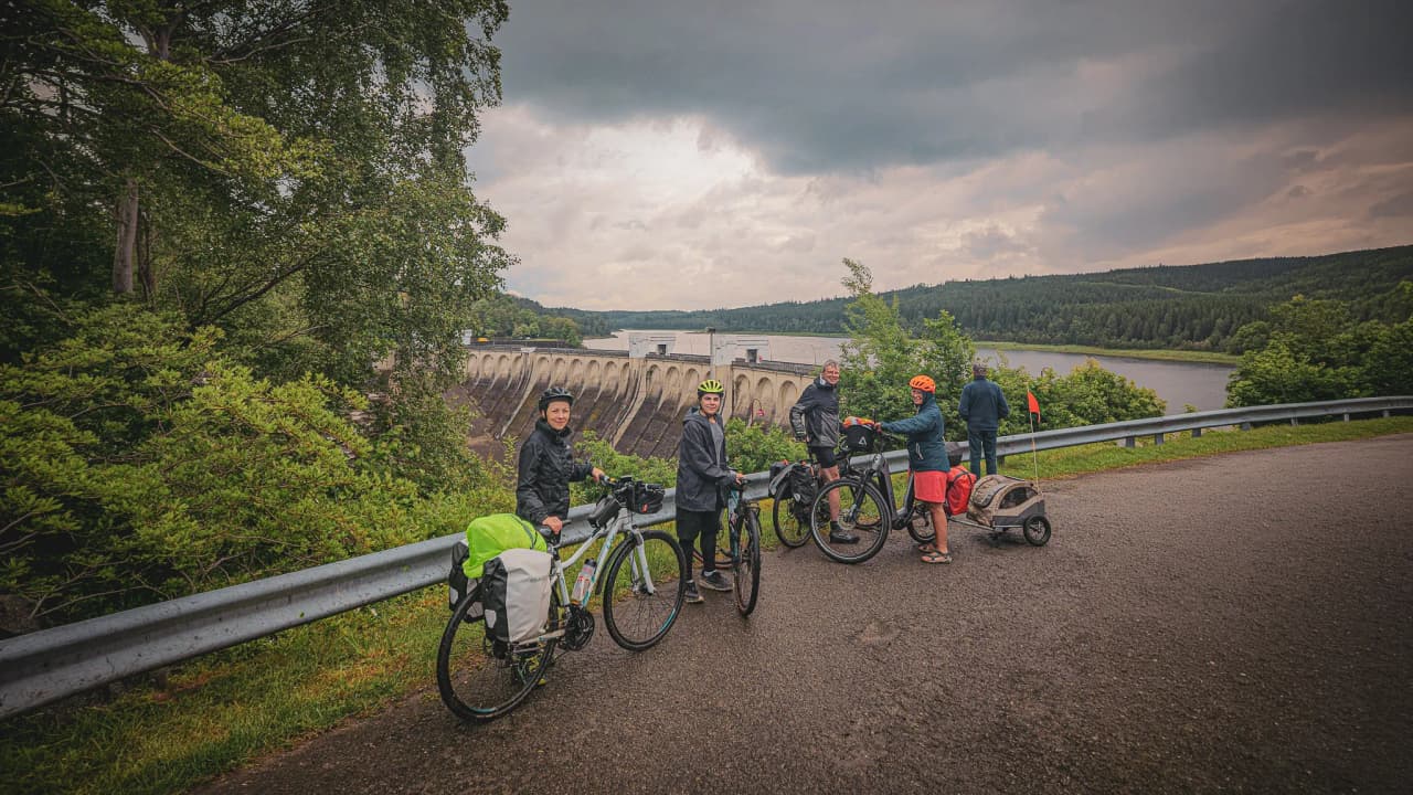 Een groep fietsers aan de rand van een groen stuwmeer, klaar voor een natuuravontuur.