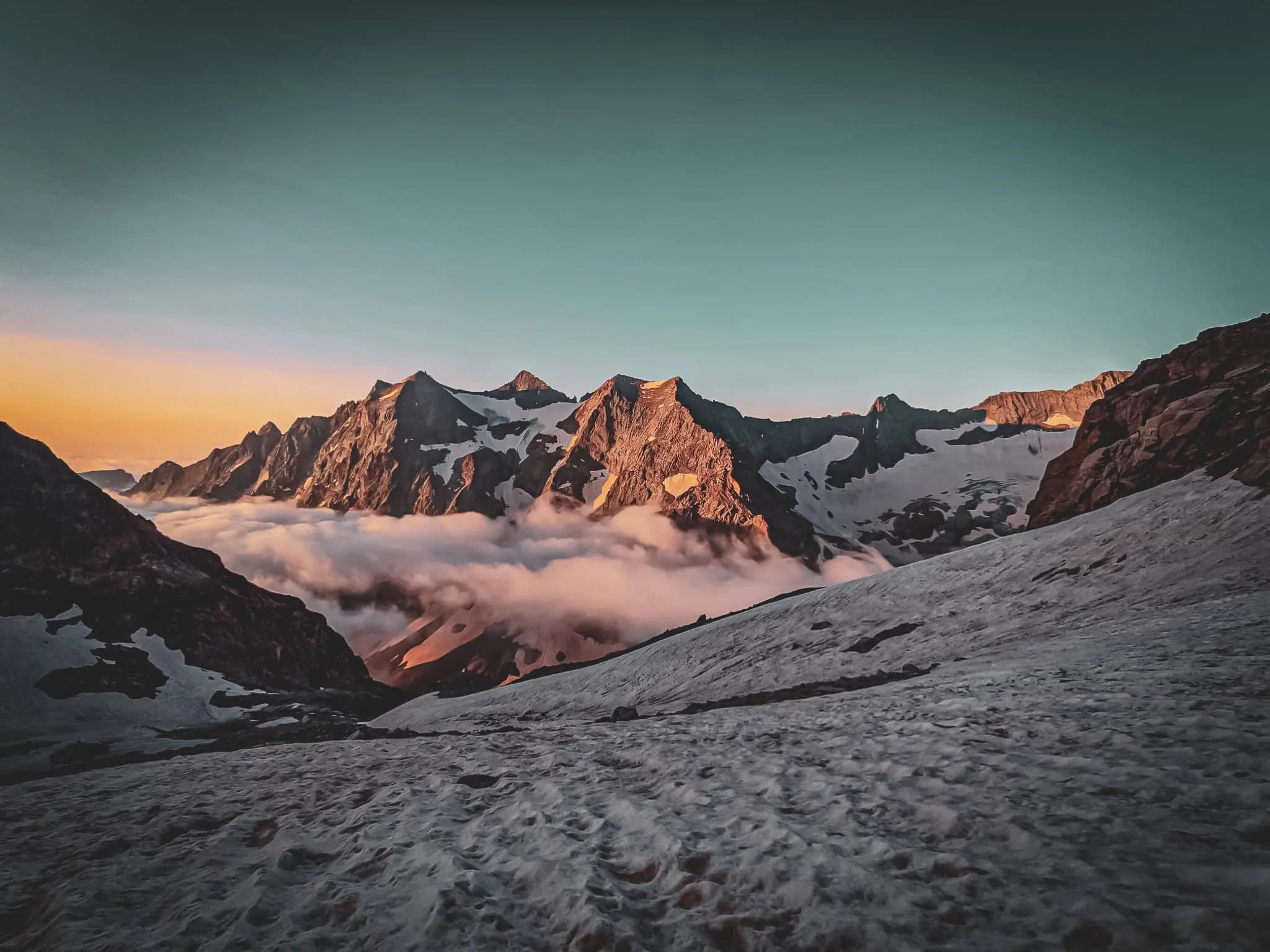 Majestueuses montagnes des Écrins, baignées de lumière dorée et de nuages, invitent à l'aventure.