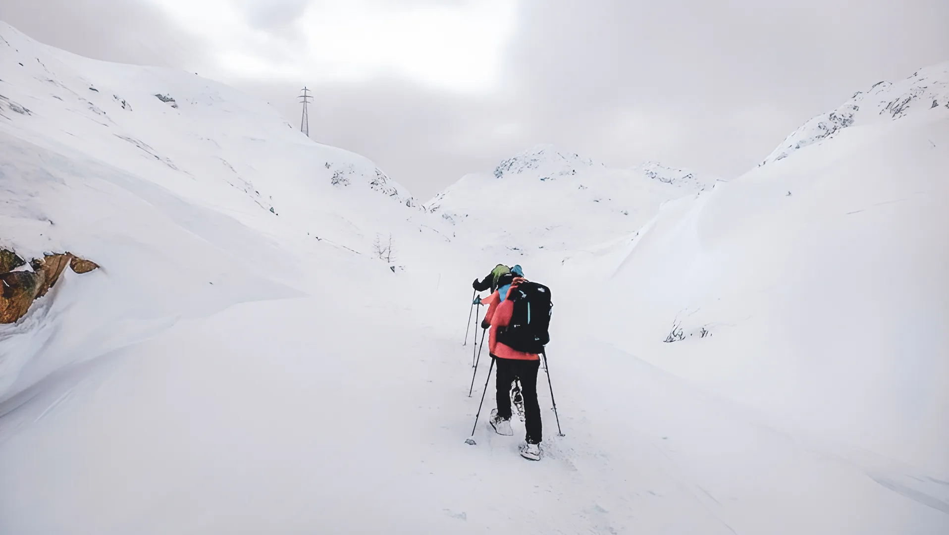 Een groep sneeuwschoenwandelaars baant zich een weg door een besneeuwd landschap op de Grote Sint-Bernard.