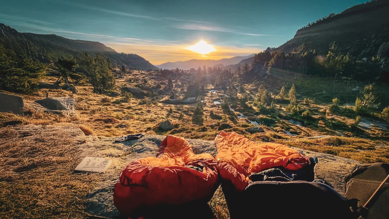 Sunset over the mountains, sleeping bags on the rocks, the promise of adventure.