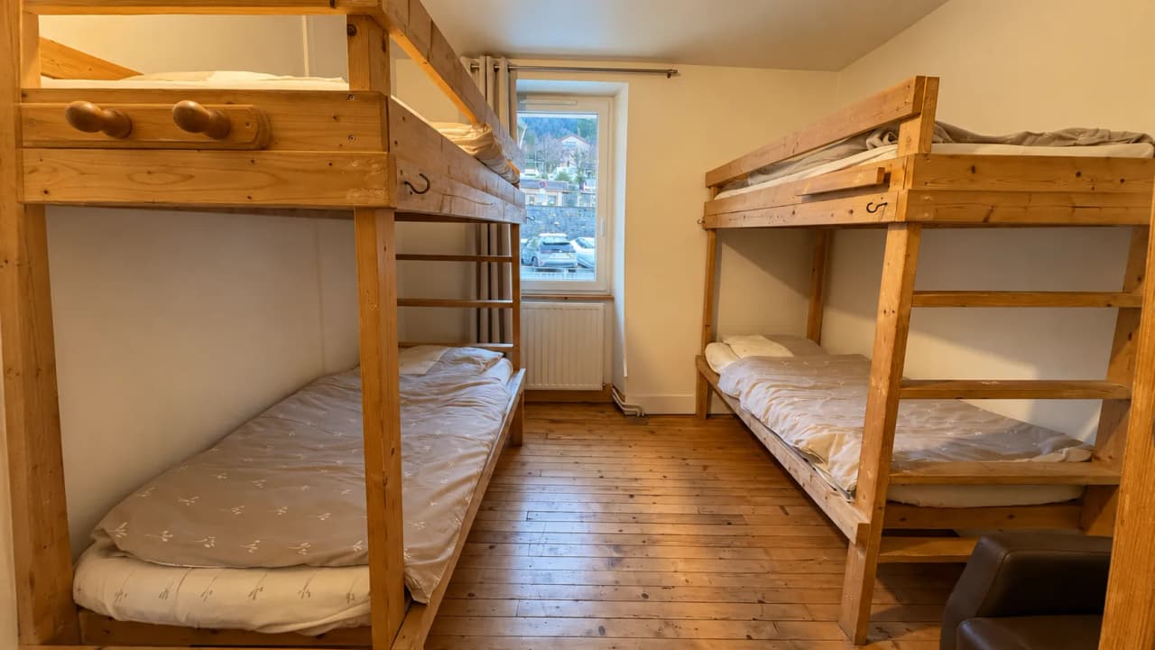 Chambre chaleureuse avec lits superposés en bois, idéale pour se reposer après l'ascension.
