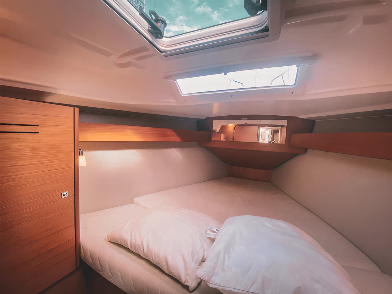 Intérieur chaleureux d’un bateau, lit confortable et lumière naturelle, prêt pour l’aventure en mer.
