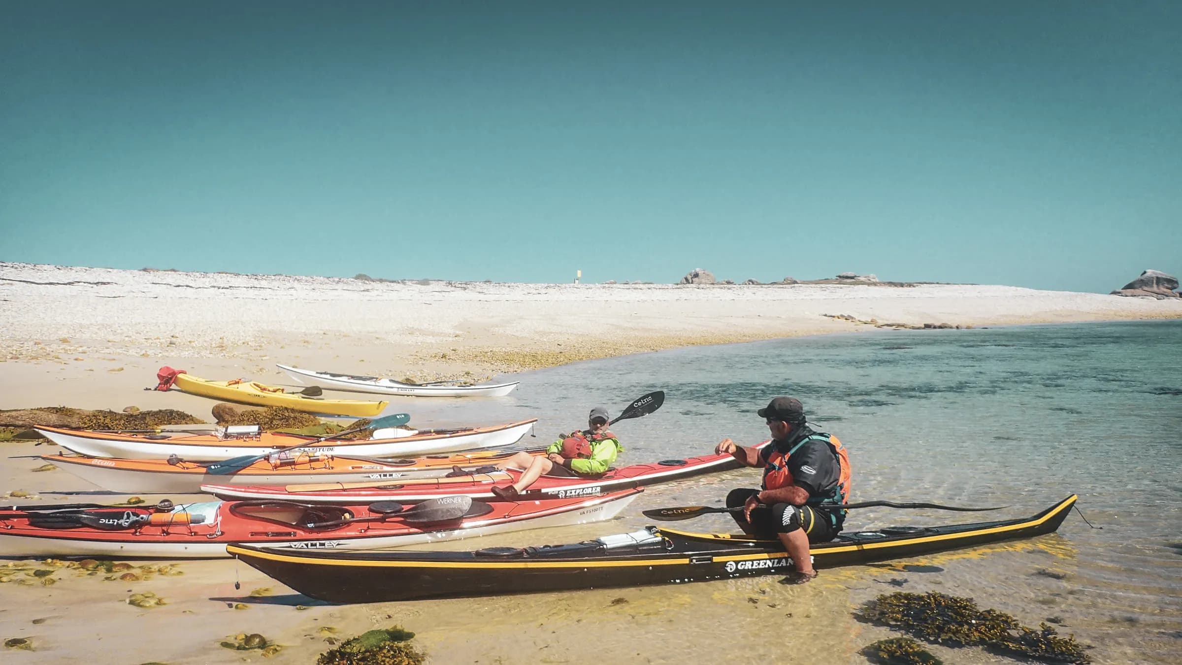 Kayakers on a golden beach, ready for an adventure in the Molène archipelago.