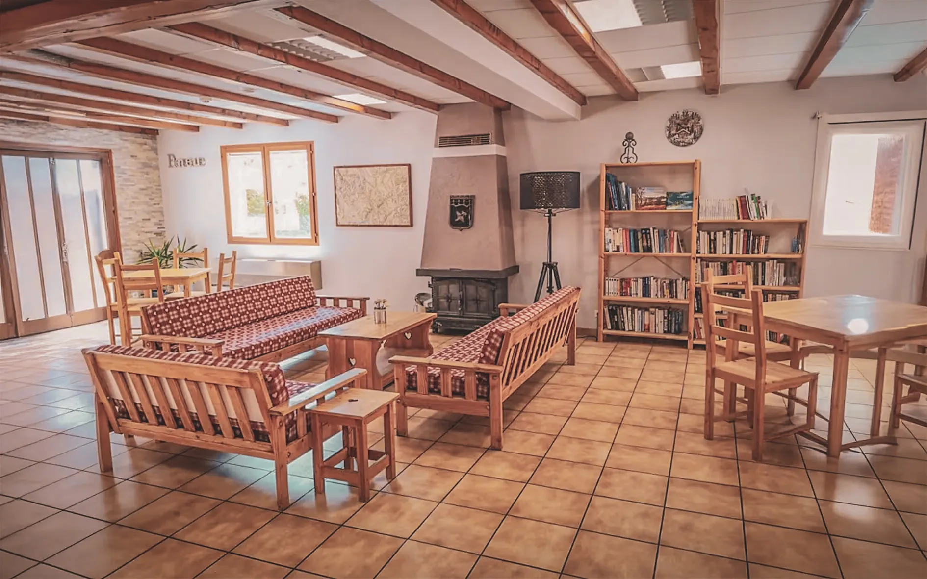 An inviting space with wooden sofas, a library and natural light, perfect for relaxing after an adventure.