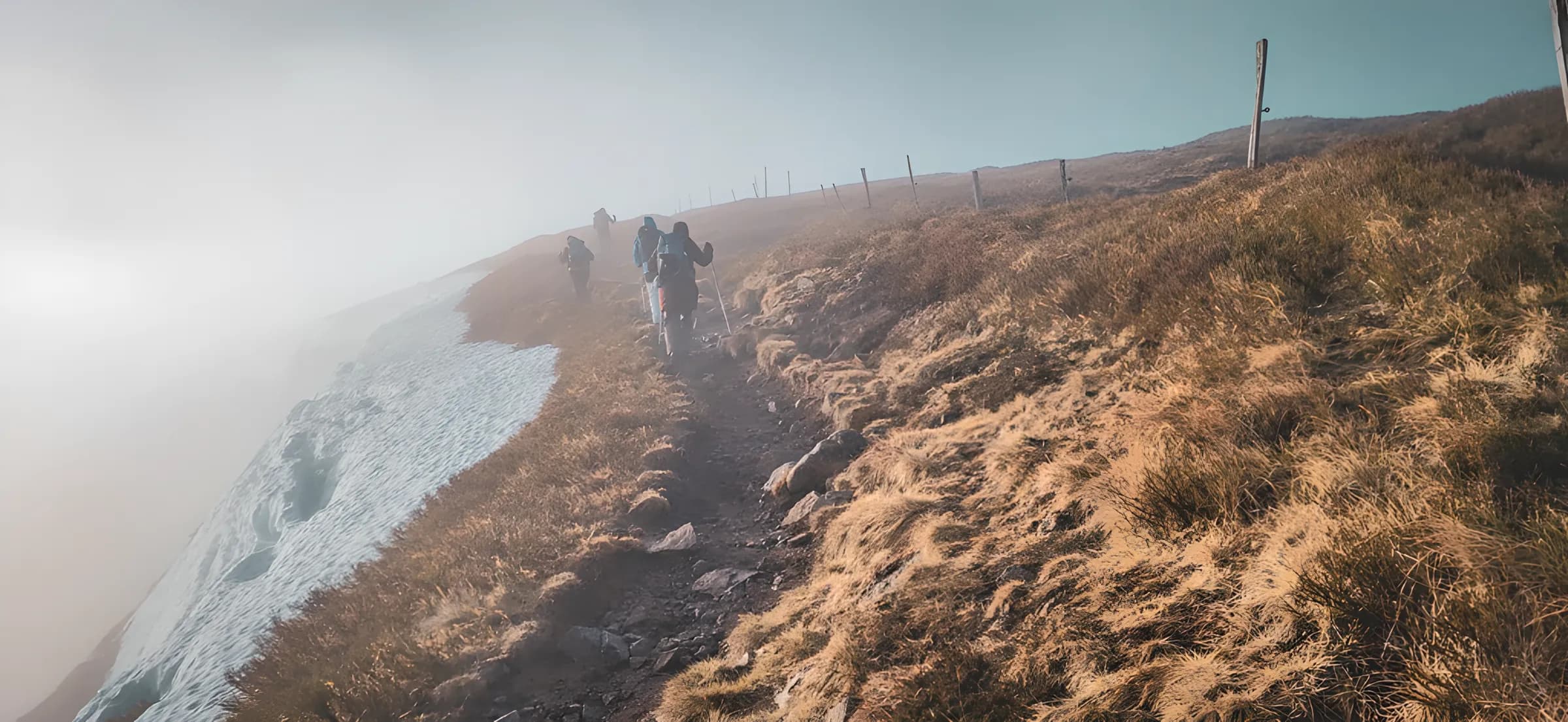 Un groupe de randonneurs sur un sentier des Vosges, entouré de brume et de paysages enneigés.