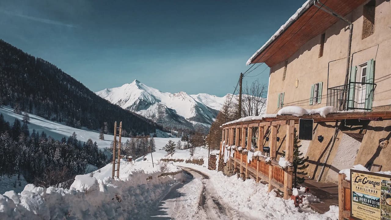 Chalet chaleureux au milieu des montagnes alpines, entouré de neige éclatante. Évasion hivernale idéale.