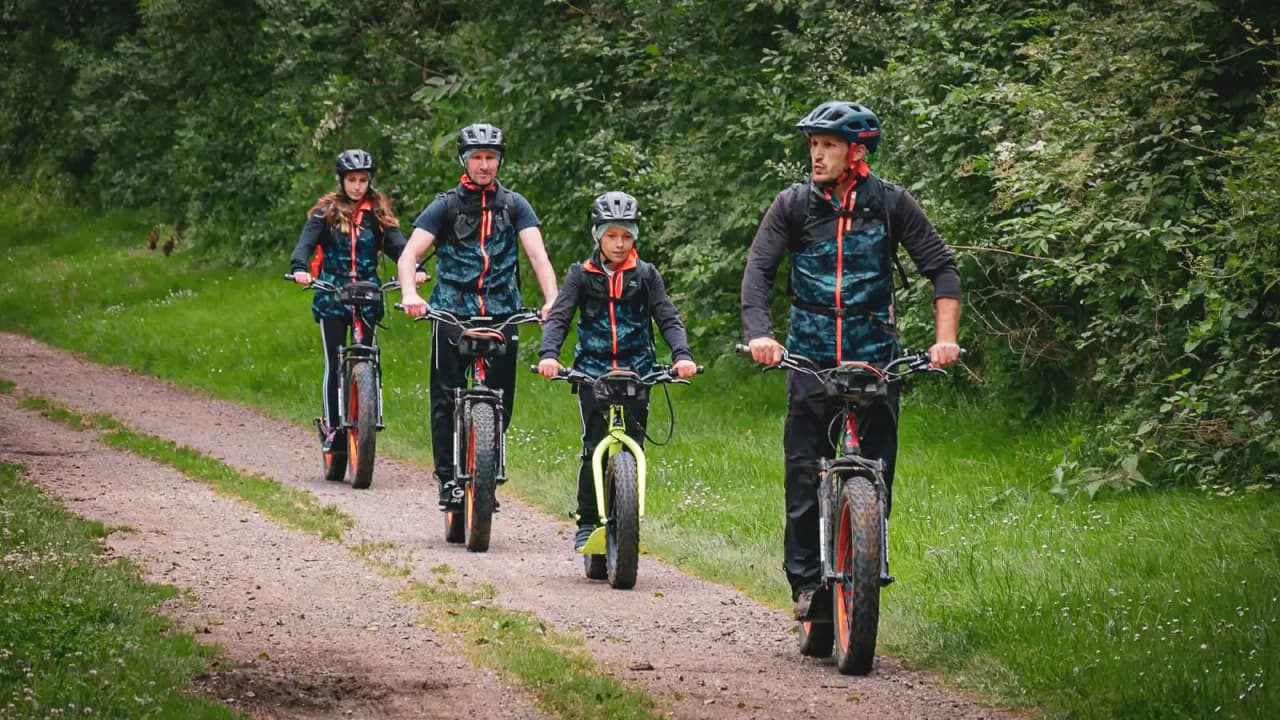 Vijf mensen op fietsavontuur op een groen pad in Zweeds Lapland.