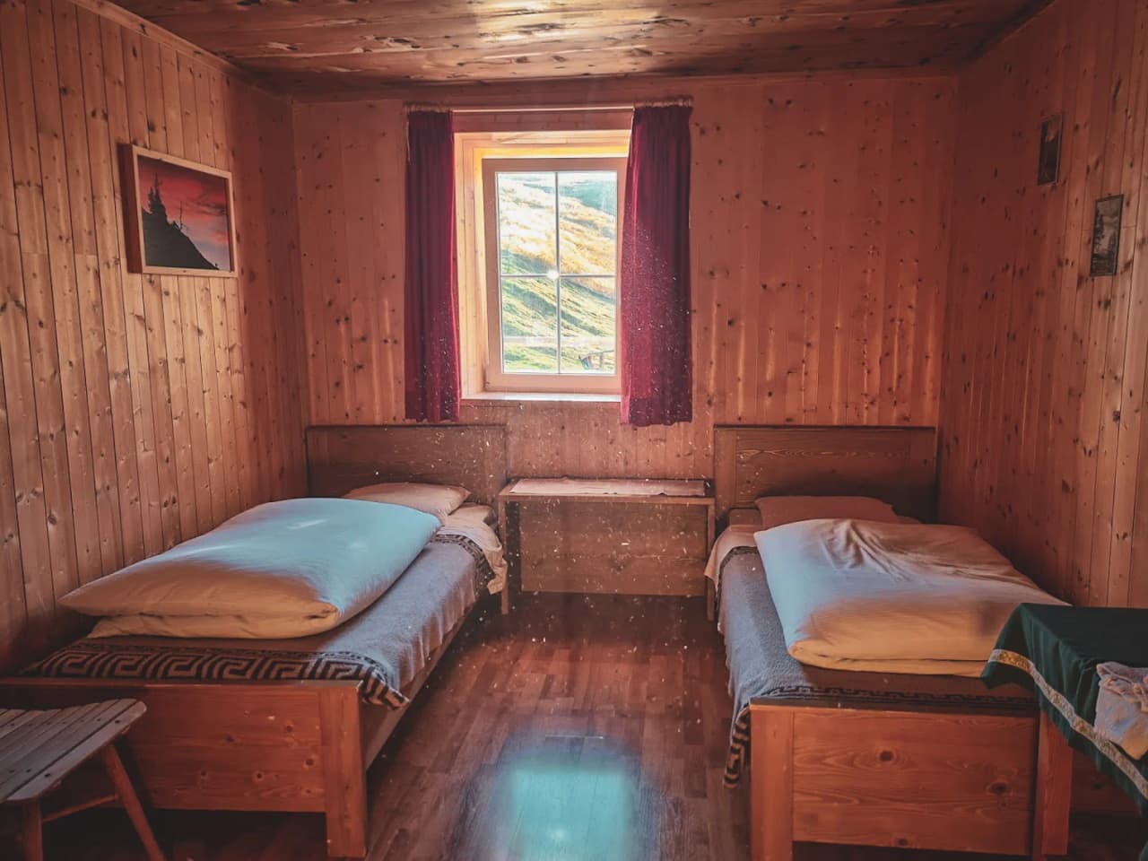 Warm wooden room with cosy beds and mountain views.