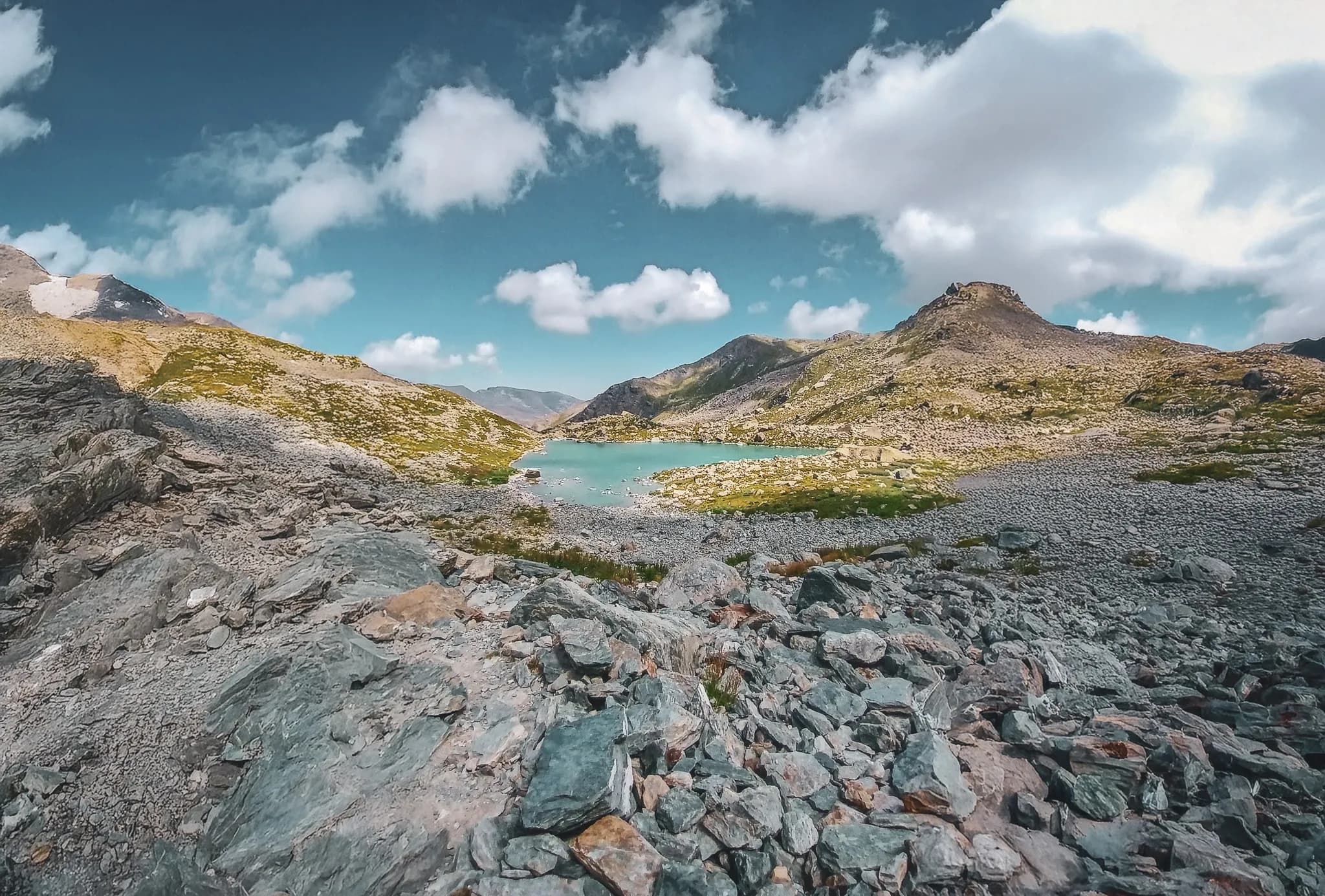 Een vredig meer omringd door majestueuze bergen en rotspartijen, een uitnodiging tot alpien avontuur.