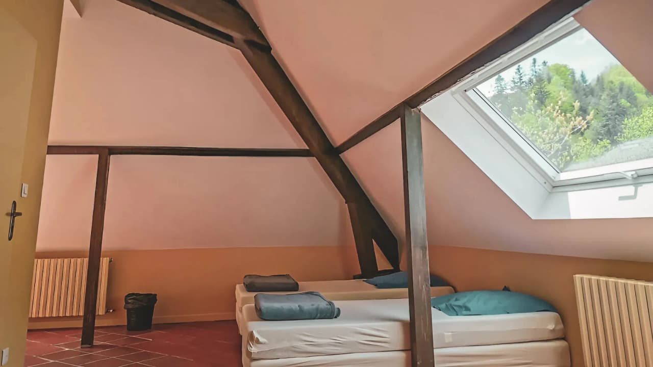 Chambre chaleureuse sous les toits, lumineuse, invitant à l'aventure dans les Pyrénées.