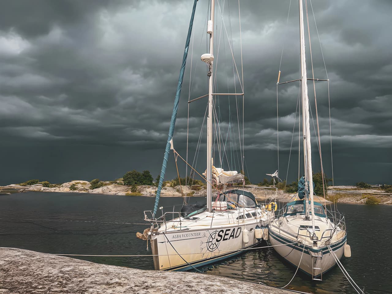 Voiliers amarrés sous un ciel nuageux, invitant à une aventure maritime au Pays de Galles.
