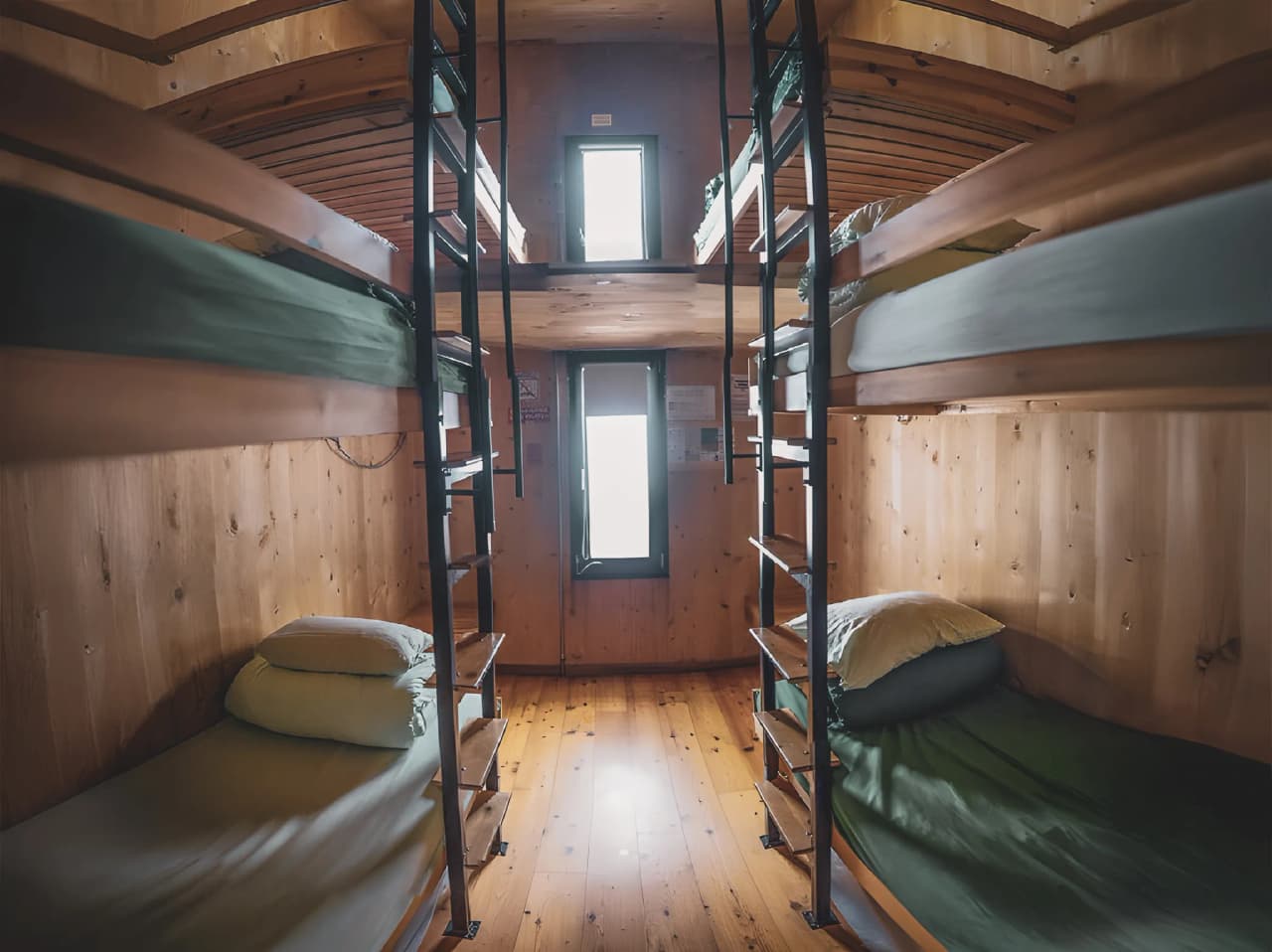 Chambre chaleureuse en bois avec lits superposés, offrant une vue sur les montagnes. Parfait pour les randonneurs !