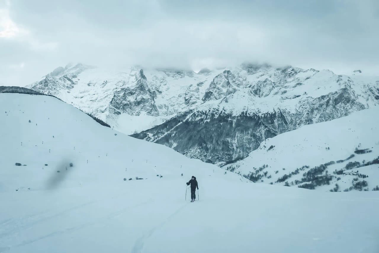 Un skieur solitaire s'illustre dans un paysage alpin enneigé à La Grave, appelant à l'aventure.