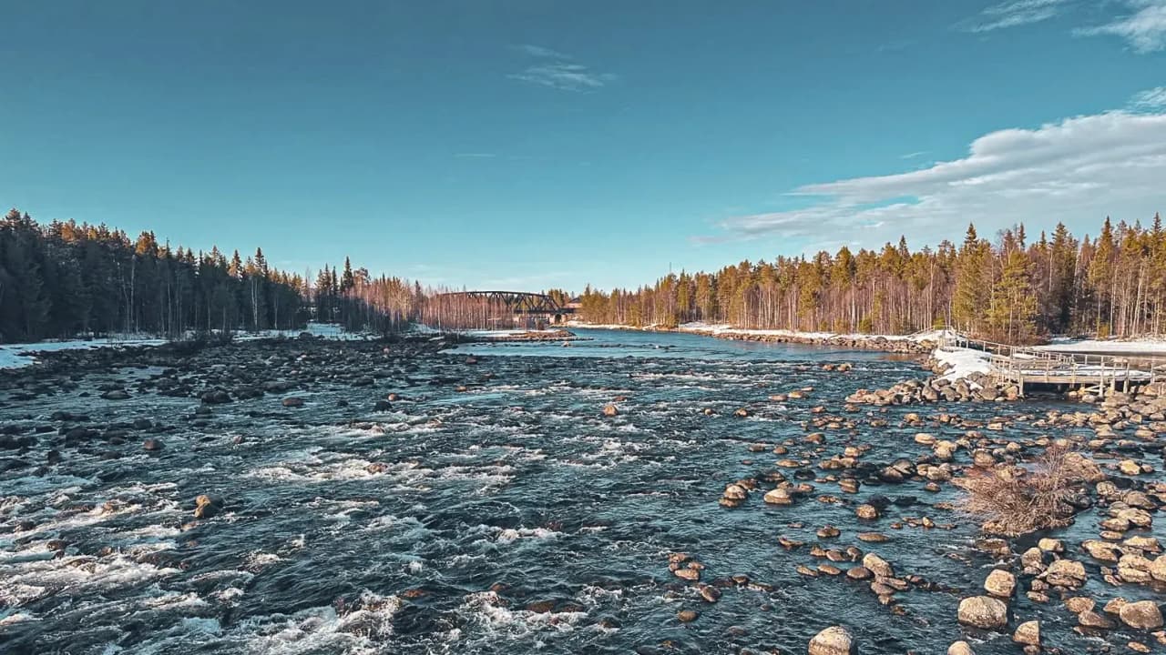 Een vredige kloof in Zweeds Lapland, omgeven door bossen en kristalhelder water.