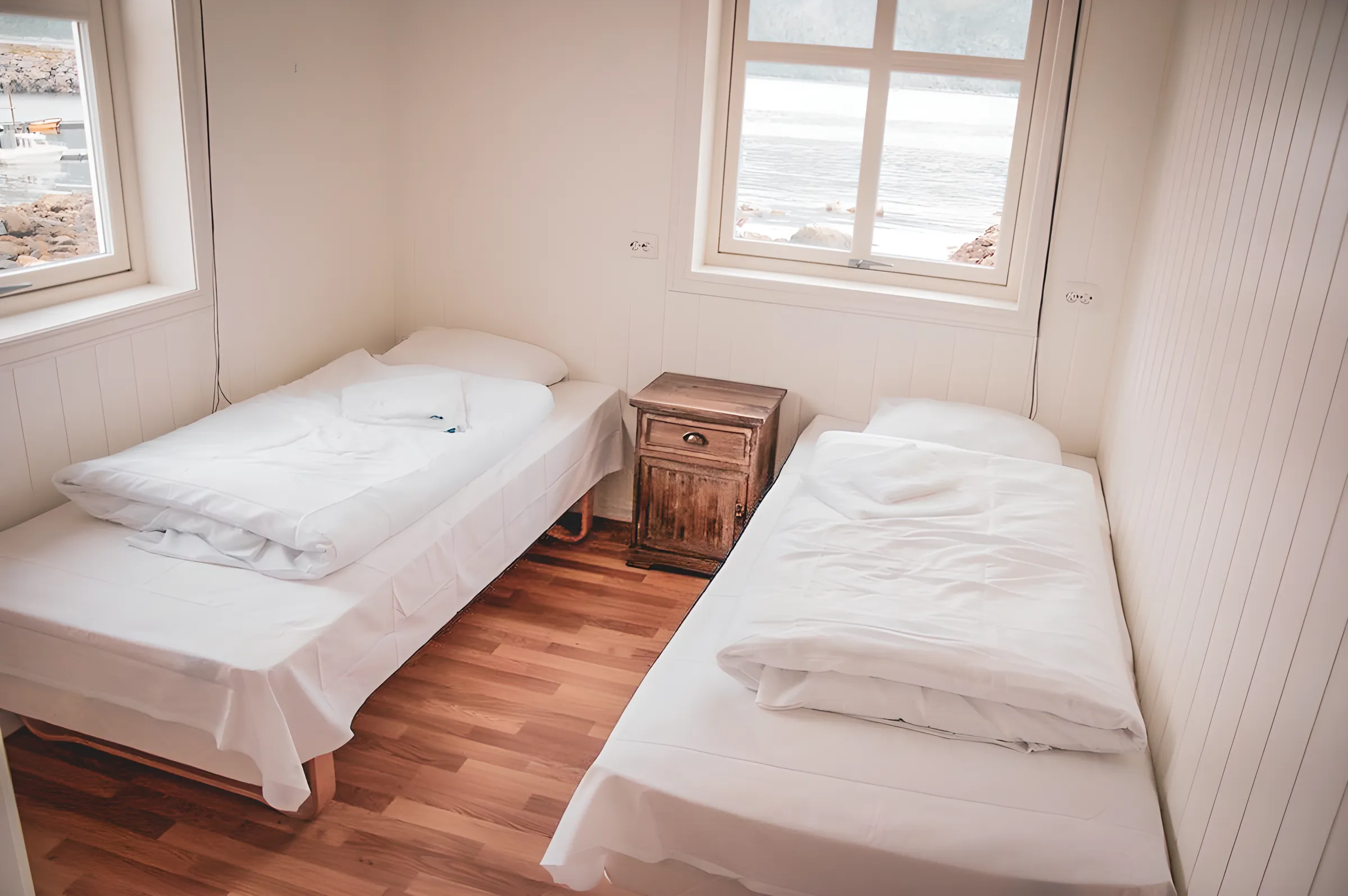 Cosy room with two beds, soothing view of the Norwegian fjord, perfect for relaxing.