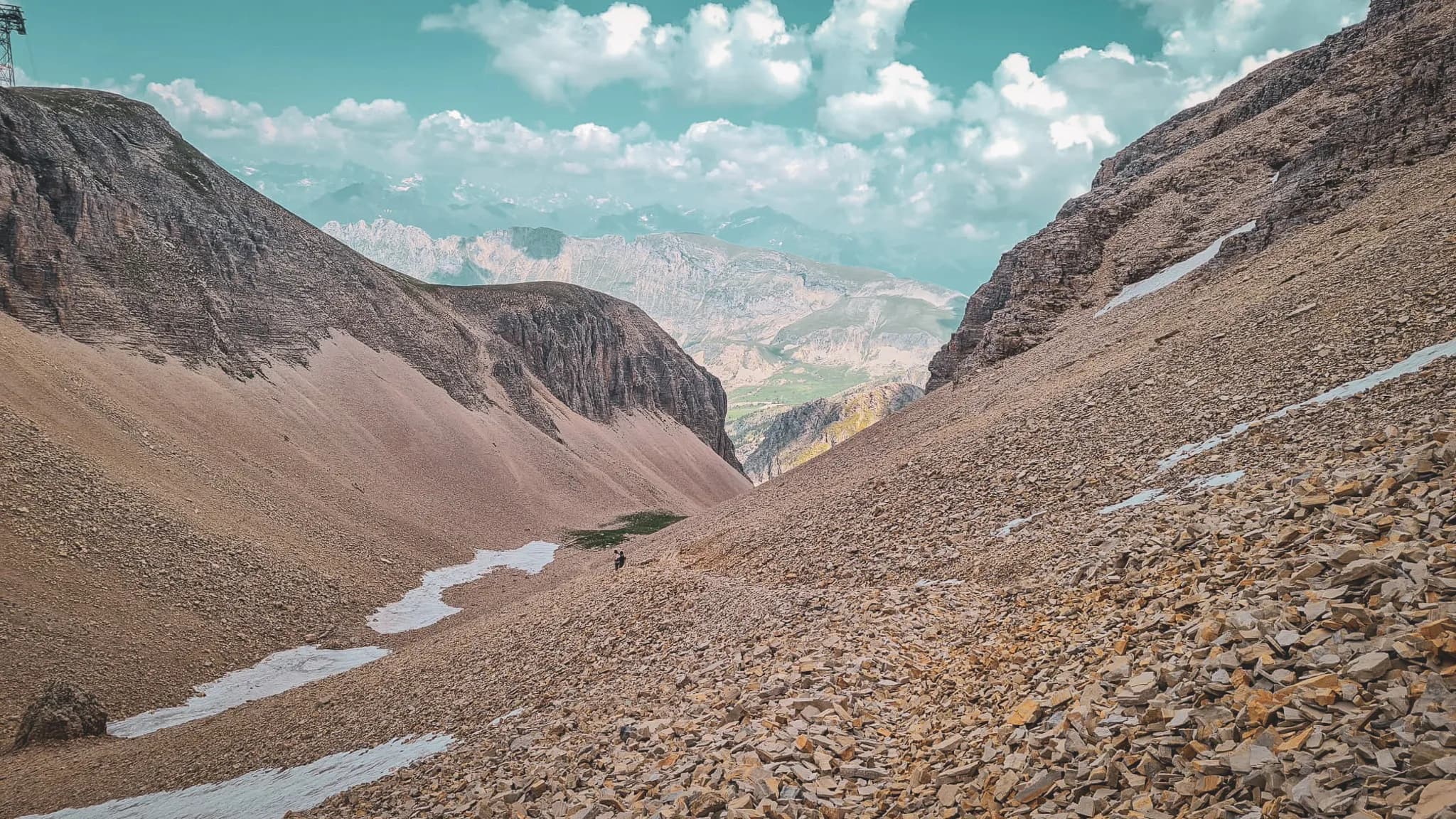 A vast Alpine landscape with majestic ridges and scattered rocks, inviting you to embark on an adventure.
