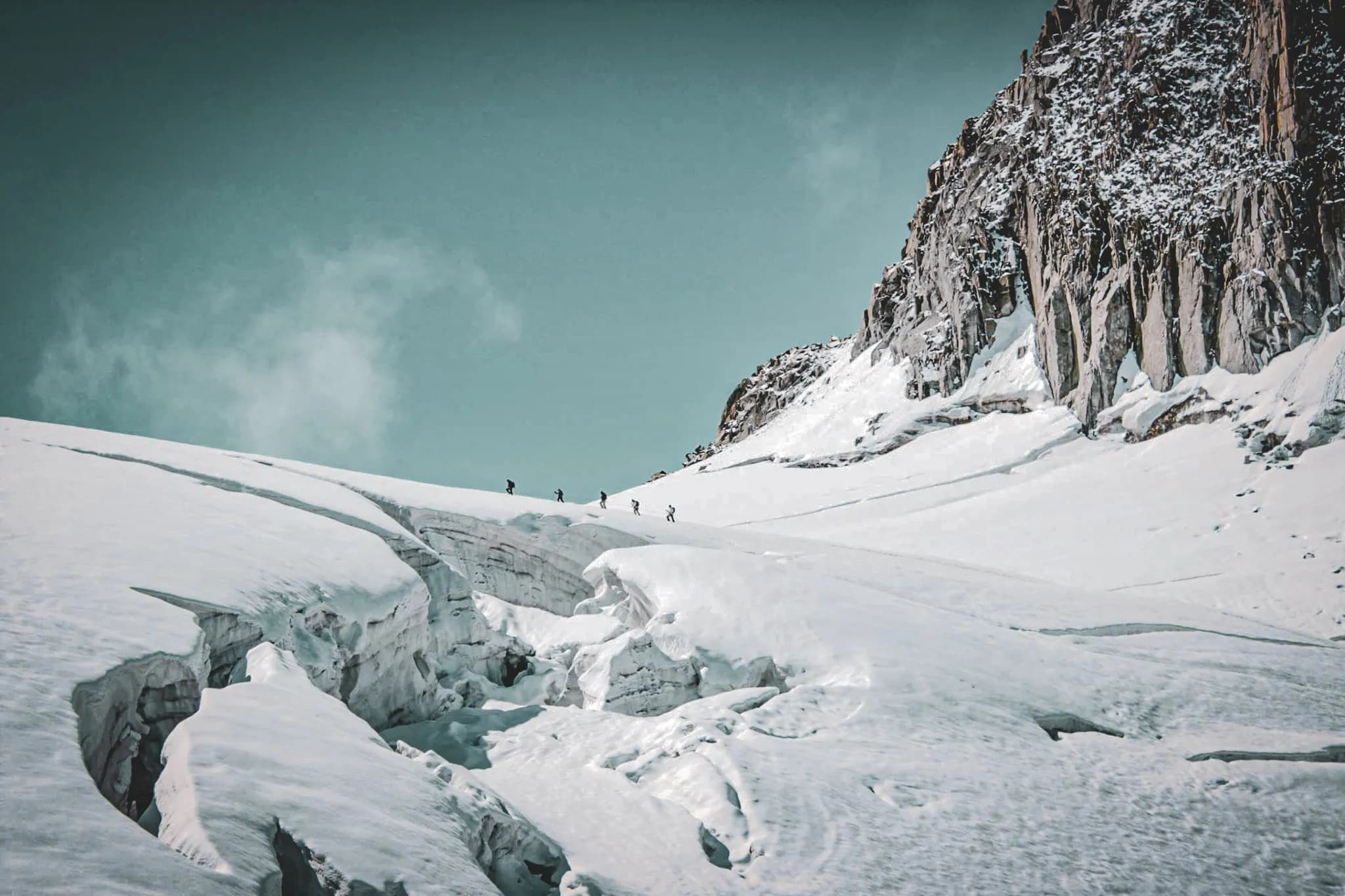 Un groupe d'alpinistes sur une neige éclatante, face à la majestueuse montagne du Mont Blanc.