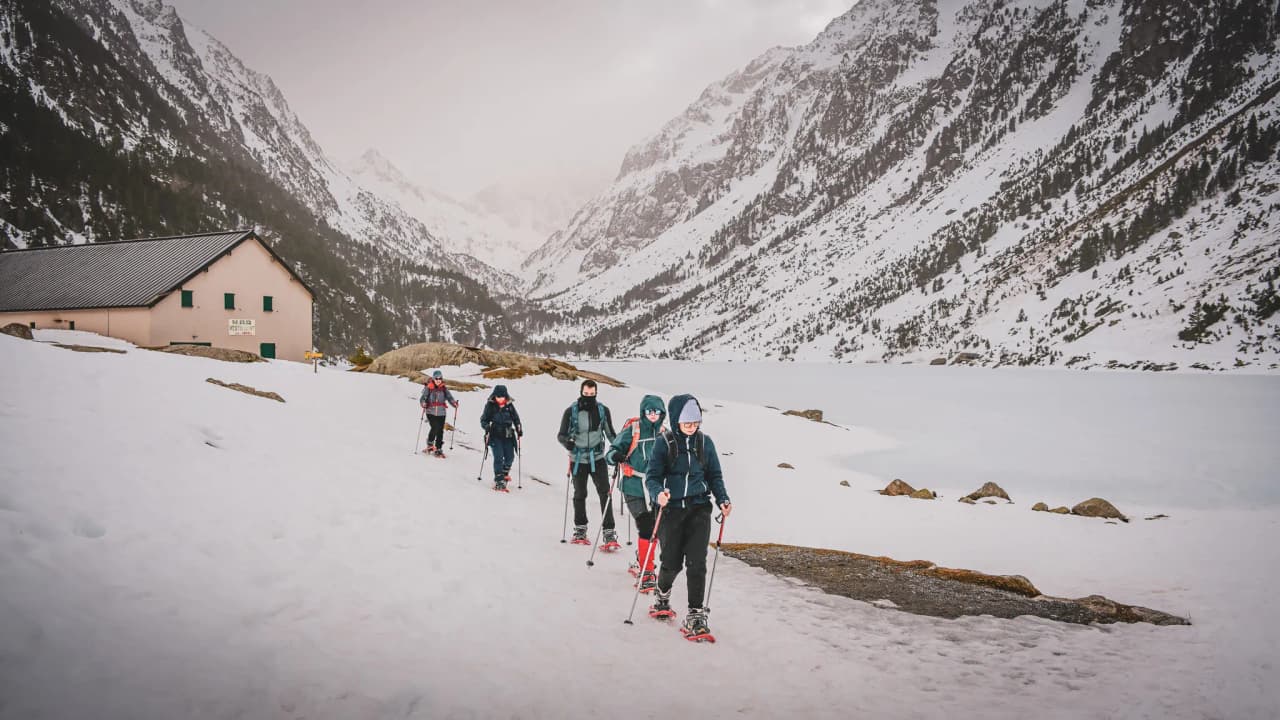 A group of hikers on snowshoes, traversing the snowy landscapes of the Pyrenees.