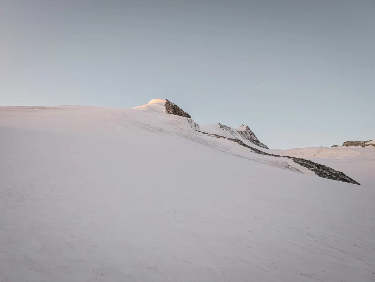 A majestic alpine landscape, immaculate snow and majestic summits under clear skies.