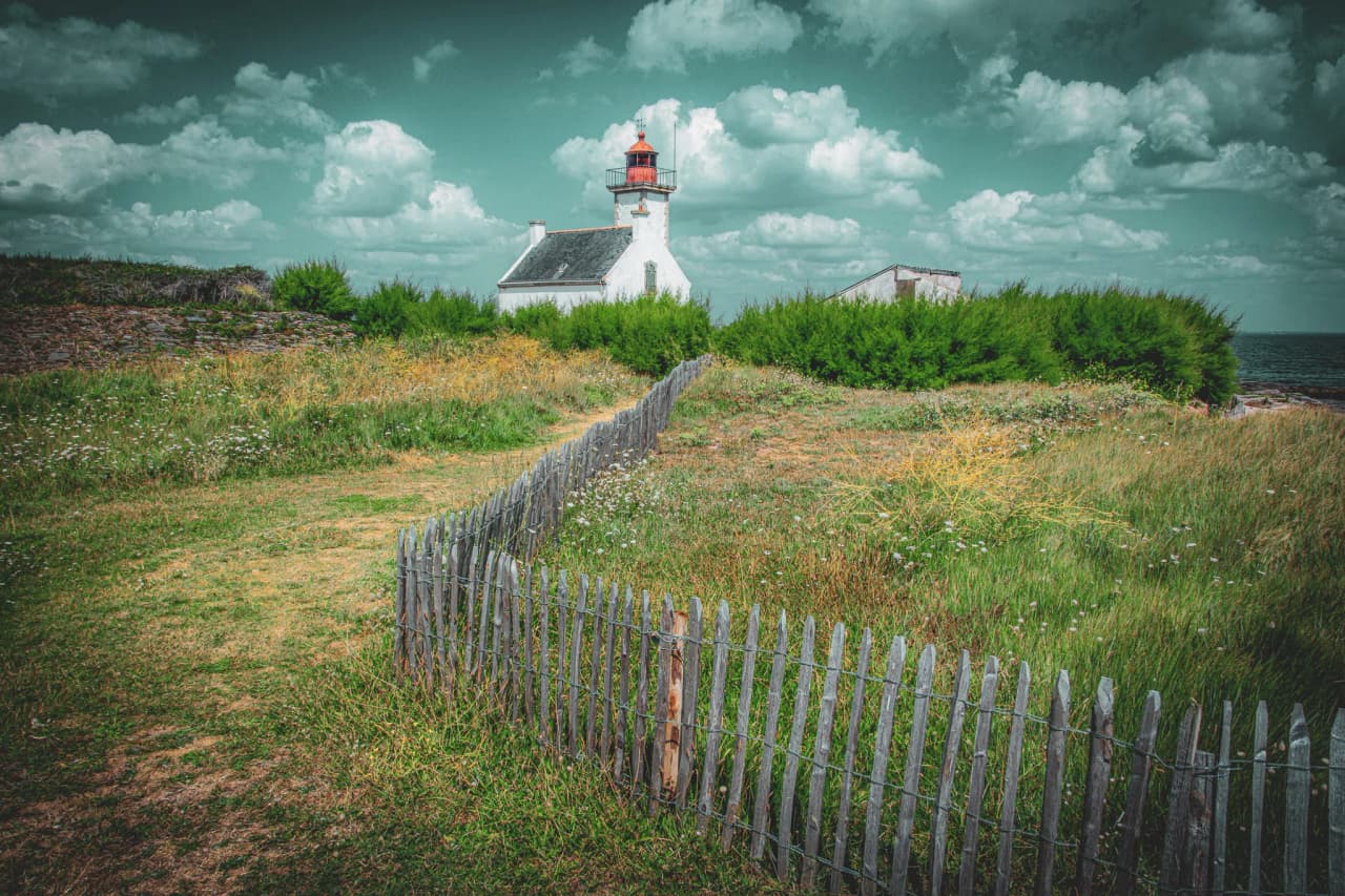 Een schilderachtige vuurtoren omgeven door groen, met uitzicht op de Atlantische Oceaan, nodigt je uit om te ontsnappen naar Bretagne.