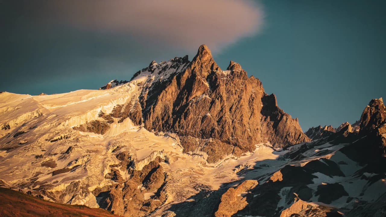 The majestic summit of the Écrins, illuminated by the sunset, offering a breathtaking panorama.