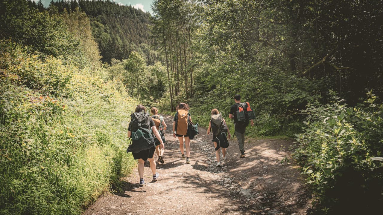 Een groep wandelaars op een groen pad midden in de natuur, in de Semoisvallei.