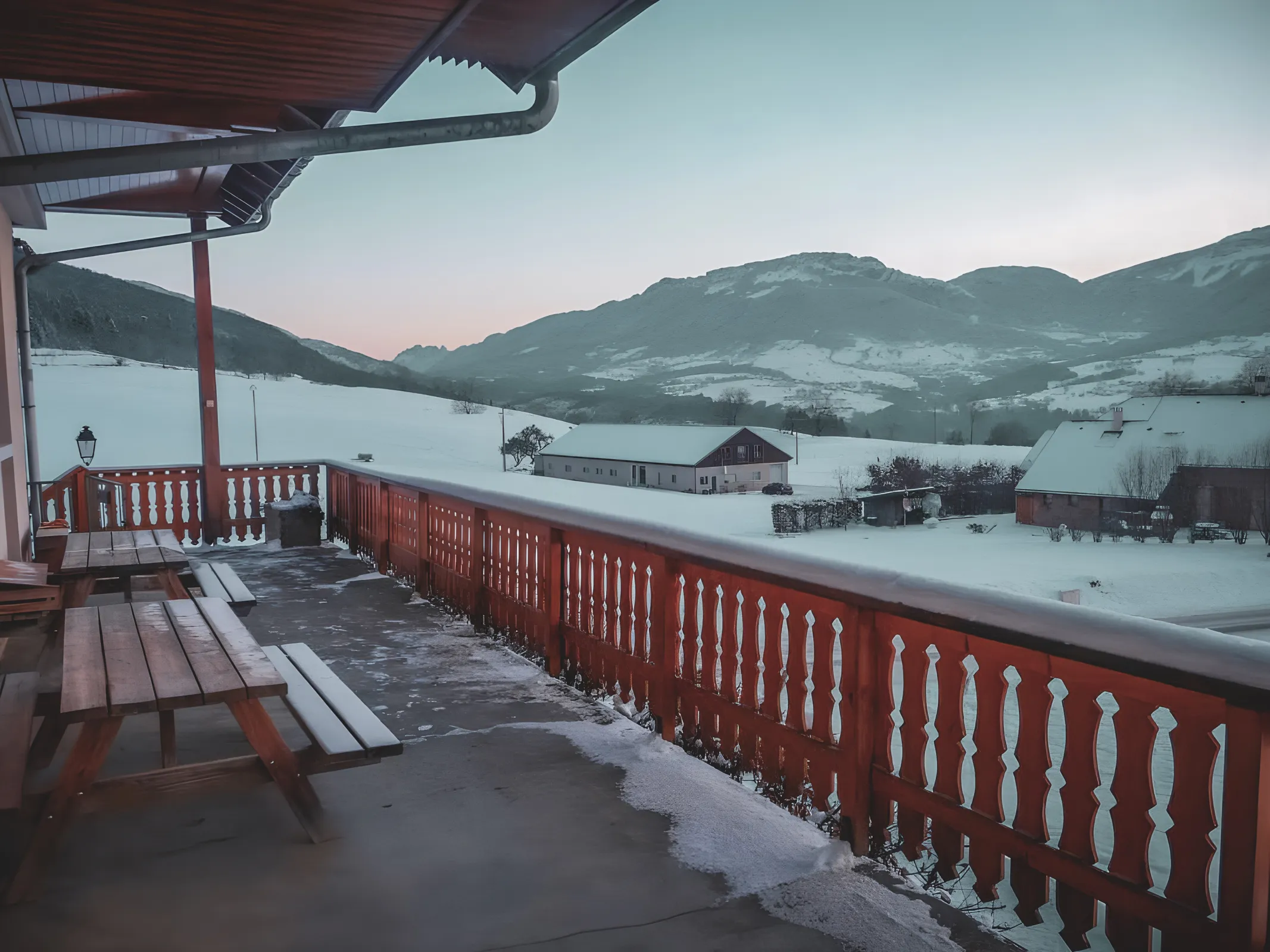 Balcon en bois avec vue sur un paysage enneigé des Bauges, invitant à l'évasion.