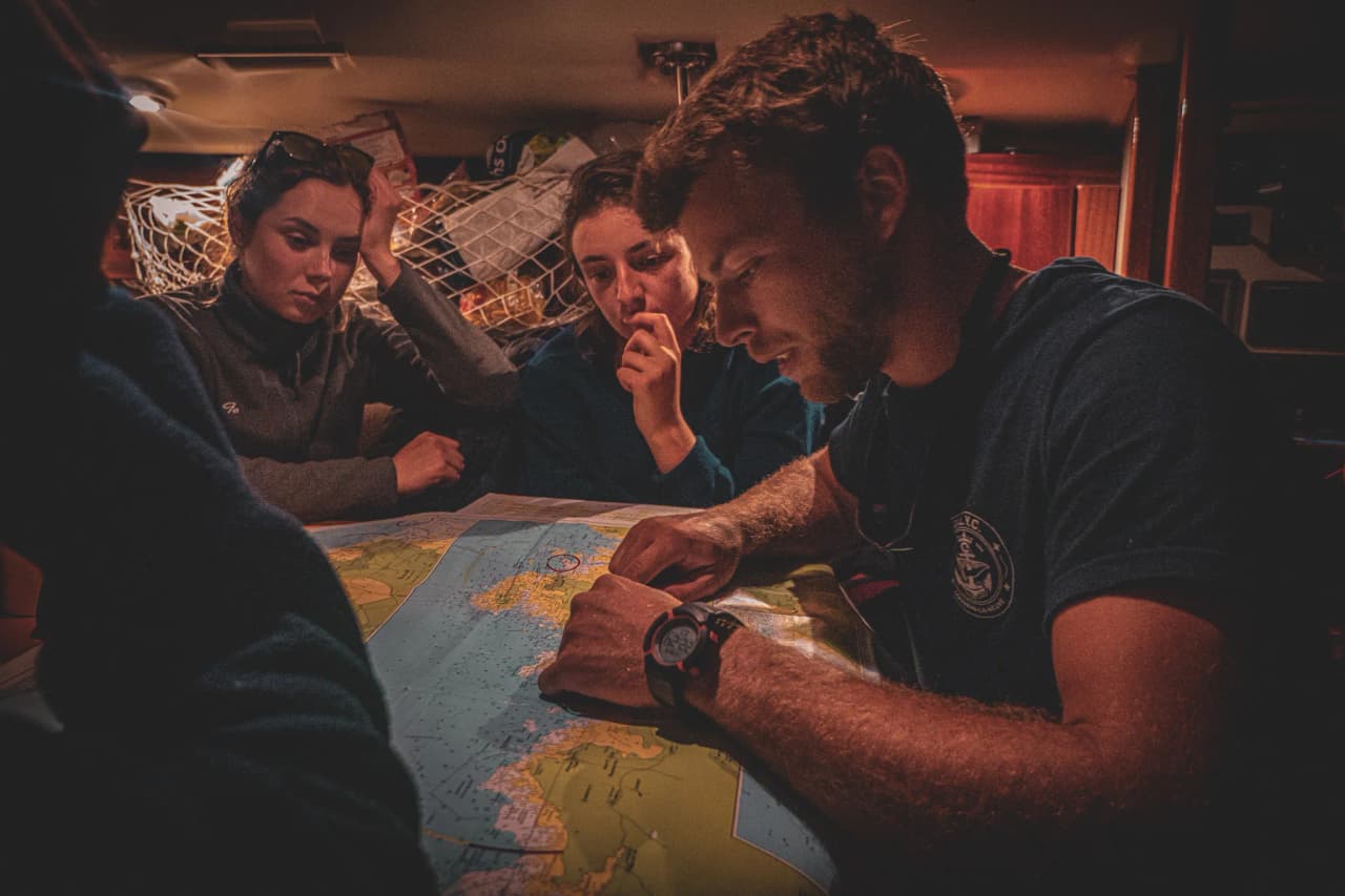Een groep in een boot bekijkt een kaart, klaar om de wildernis van Belle-Île in te varen.