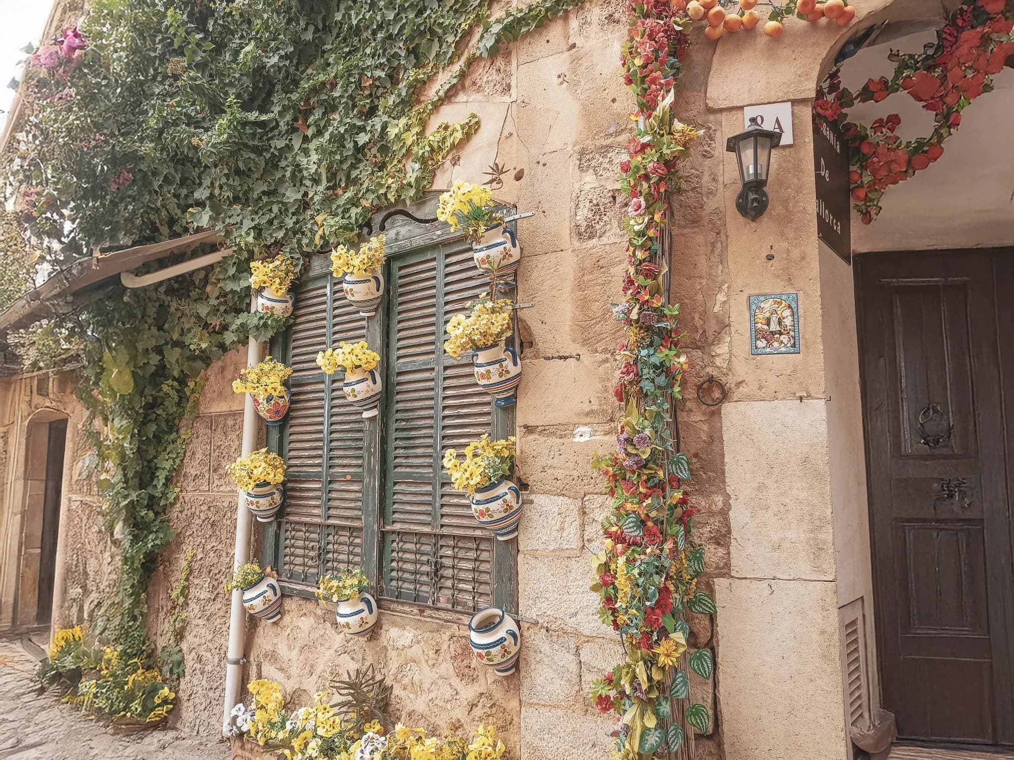 A traditional Majorcan house, adorned with colourful flowers and lush greenery.