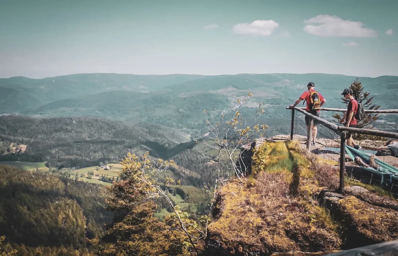 Deux randonneurs admirent un panorama saisissant sur les Vosges, entre nature et sérénité.