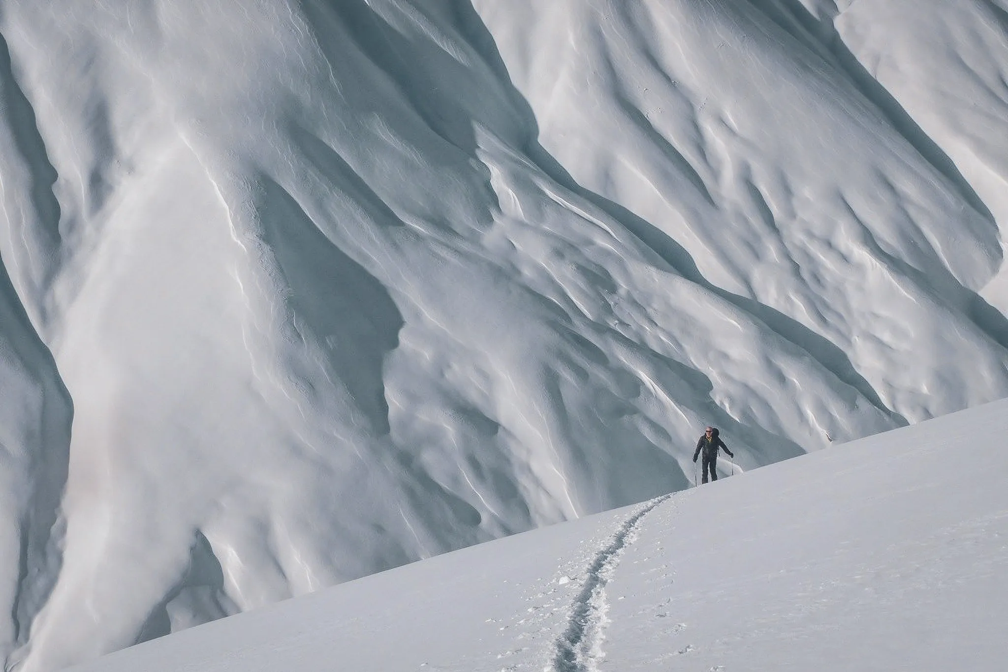 Een eenzame skiër waagt zich op de smetteloze hellingen omzoomd door majestueus ijs.
