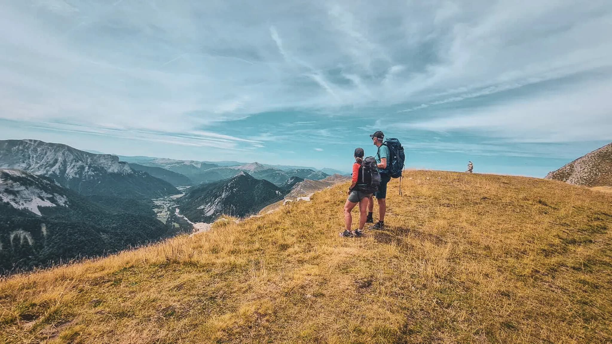 Hiking in the Dévoluy, two adventurers admire breathtaking Alpine scenery.