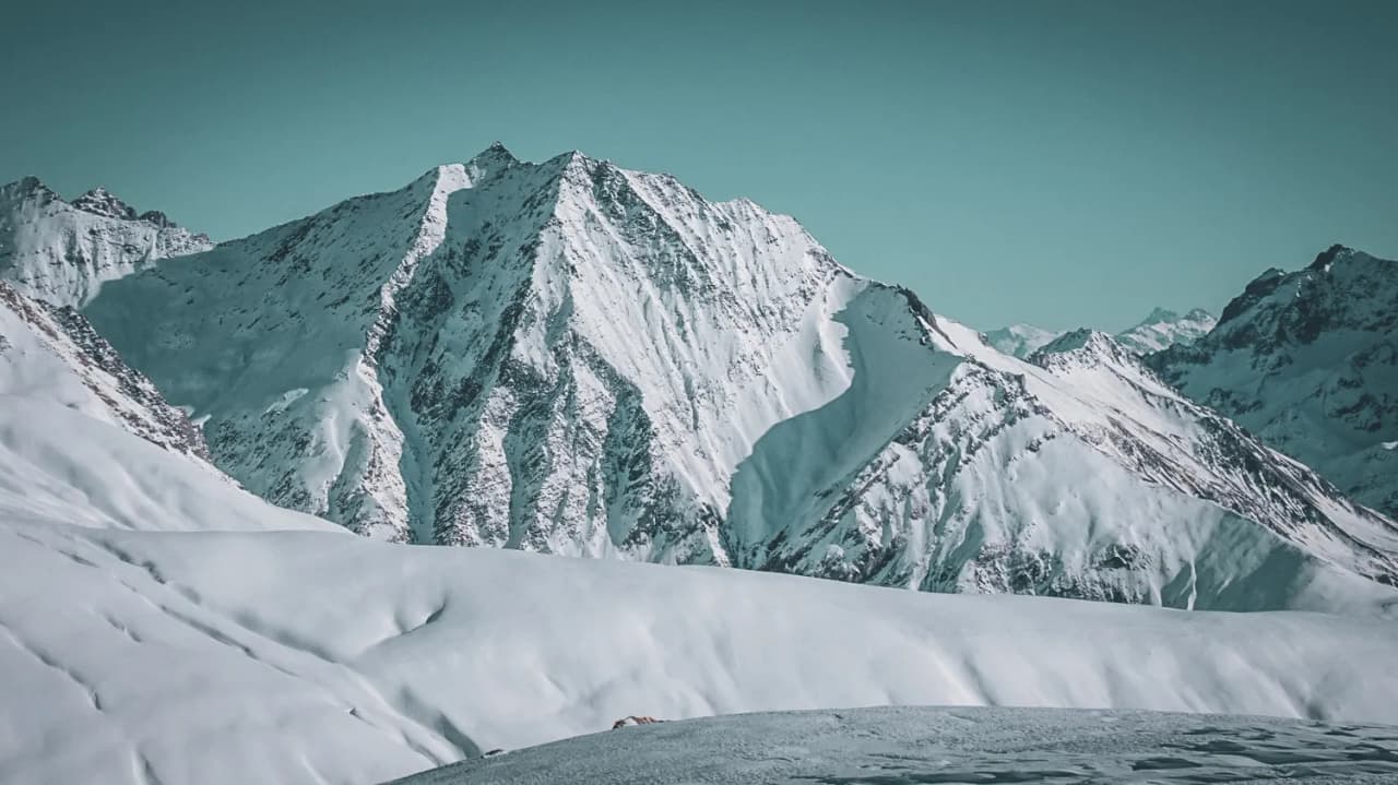 Paysages alpins majestueux, sommets enneigés et vastes champs de neige, invitation à l'aventure.