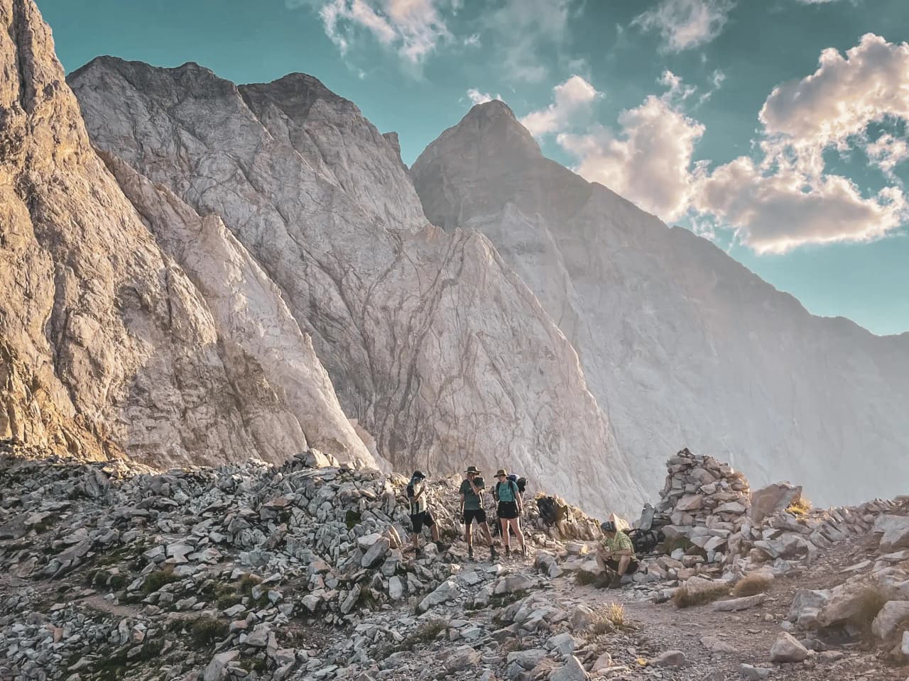 Groupe de randonneurs sur un sentier de montagne face aux majestueuses Pyrénées.