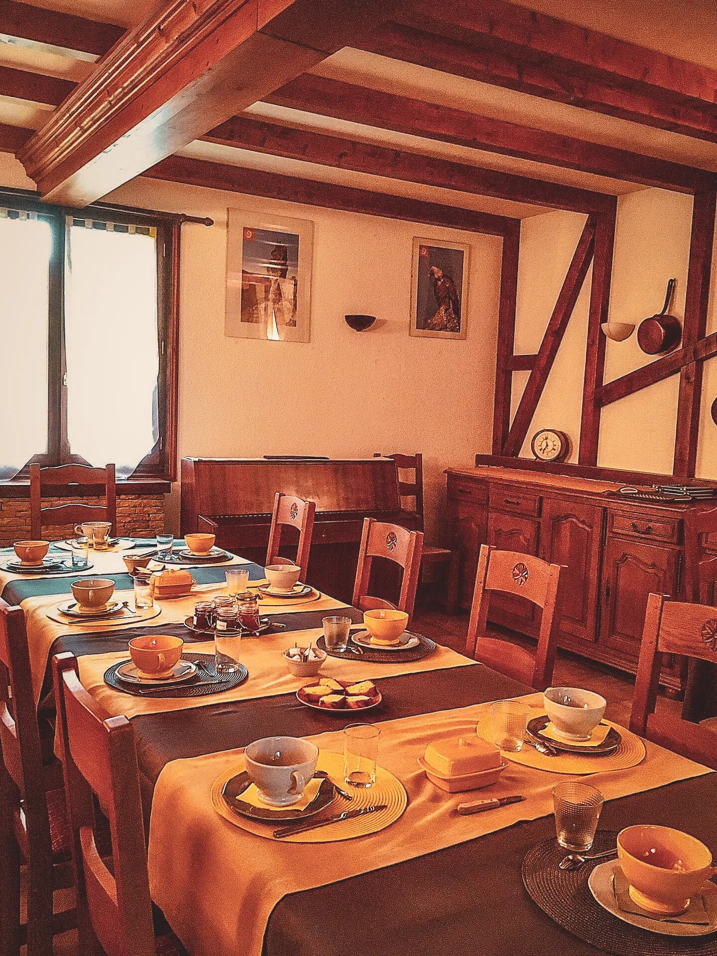 Salle à manger chaleureuse, tables dressées pour un petit-déjeuner convivial après l'aventure.
