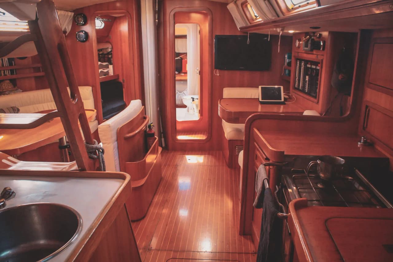 Intérieur chaleureux d'un voilier, avec bois élégant et lumière douce, promesse d'aventures maritimes.